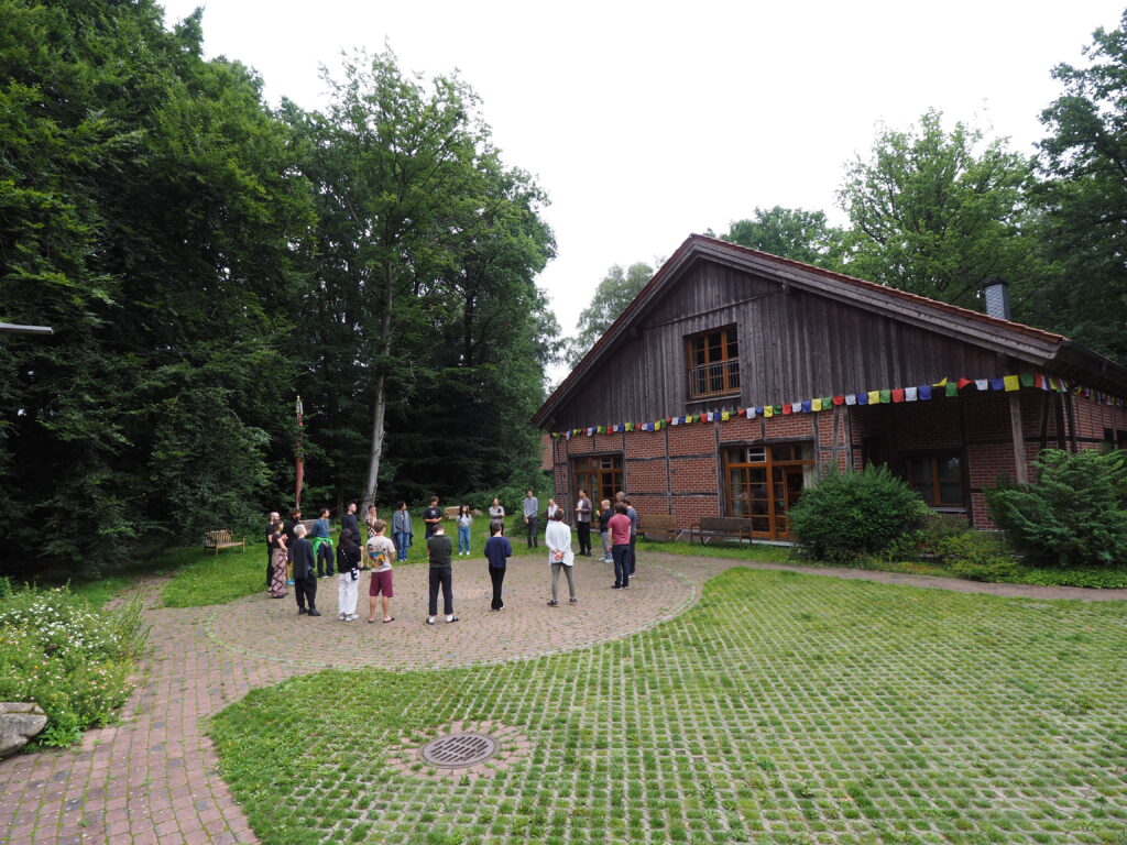 Alle stehen im Kreis vor dem Haus