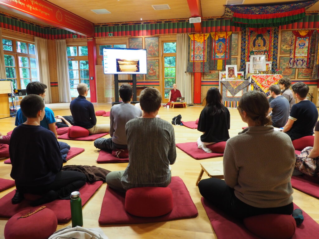 Vortrag von Thubten Jampa. Zu sehen sind die jungen Buddhistinnen und Buddhisten von hinten 